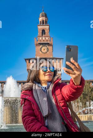 Ein Tourist macht ein Selfie vor dem Castello Sforzesco oder der Mailänder Burg im Herzen von Mailand, Italien. Stockfoto