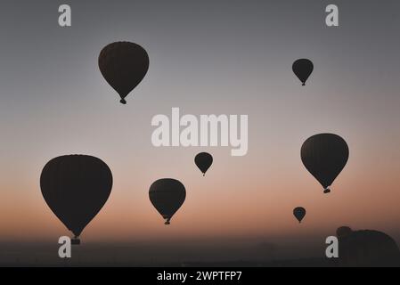 Viele Heißluftballons bei Sonnenaufgang schweben über dem Nil in Luxor, Ägypten Stockfoto