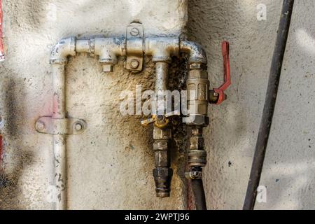 Nahaufnahme eines rustikalen Druckluftanschlusses, an eine raue Wand genagelt, in einer Autowerkstatt in der Stadt Arcabuco in Kolumbien. Stockfoto