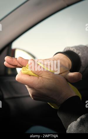 Ein älterer Mann kümmert sich um die Reinigung des Innenraums des Autos auf dem Naturparkplatz Stockfoto