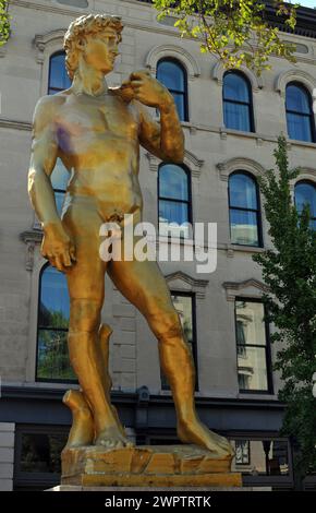 Eine goldene Reproduktion von Michelangelos David-Skulptur des türkischen Künstlers Serkan Özkaya steht vor dem 21c Museum Hotel in der Innenstadt von Louisville. Stockfoto