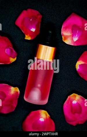 Der Pink Color Rose Wasser oder nagellack auf rosa Rosenblättern auf Closup Stockfoto