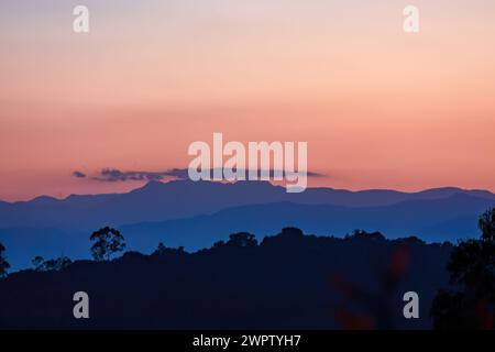 In der letzten Minute des Sonnenuntergangs ist ein fast klarer Himmel mit einem wunderschönen rosafarbenen Schatten erfüllt, über den östlichen Andengebirgen in Zentral-Kolumbien. Stockfoto