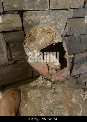 Porträt einer Vintage-Puppe auf dem Hintergrund einer Steinmauer Stockfoto