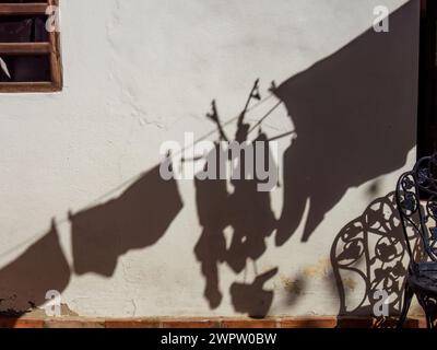 Der Schatten der Kleidung, die trocken hängt, gegossen von der Morgensonne, in einem Haus in der Nähe der Stadt Arcabuco in Zentral-Kolumbien. Stockfoto