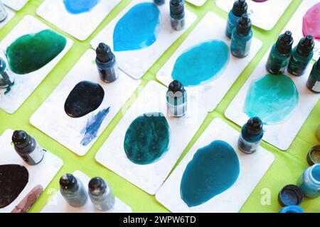 Farbflaschen für Kunstharzkunst. Mischen von Epoxid in Kunststoffbechern zur Gießstabilisierung und Hybridbehandlung. Kunstmalerei Stockfoto