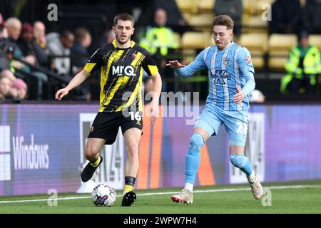 Watfords Giorgi Chakvetadze (links) und Josh Eccles aus Coventry City kämpfen um den Ball während des Sky Bet Championship Matches in der Vicarage Road, Watford. Bilddatum: Samstag, 9. März 2024. Stockfoto