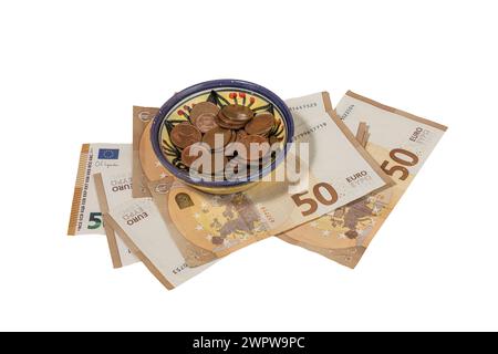 Einige Euro-Pennys in einer dekorierten Schüssel und einige Banknoten auf transparentem Hintergrund Stockfoto