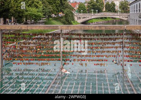 LJUBLJANA, SLOWENIEN - 5. JUNI 2022: Die Metzgerbrücke (Slowenisch: Mesarski Most), eine Fußgängerbrücke über den Fluss Ljubljanica. Auf seinen Stahldrähten ist Stockfoto