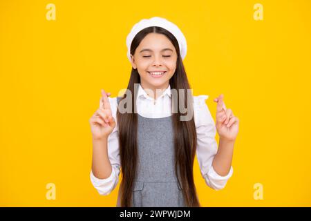 Porträt von entzückenden kleinen Teenager-Gitl stehen mit geschlossenen Augen und Kreuzungen Finger, Wunsch nach Viel Glück. Kindheitsträume und Hoffnungen. Stockfoto