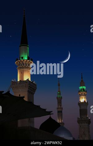 Eine Moschee mit dem Vollmond am Himmel. Masjid nabi von Medina, Moschee in der Nacht. Masjid nabi von Medina. Grüne Kuppel und Mond... Stockfoto