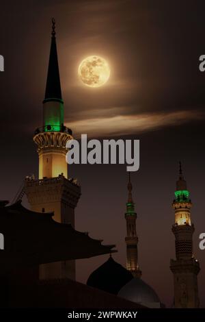 Eine Moschee mit dem Vollmond am Himmel. Masjid nabi von Medina, Moschee in der Nacht. Masjid nabi von Medina. Grüne Kuppel und Mond. Stockfoto