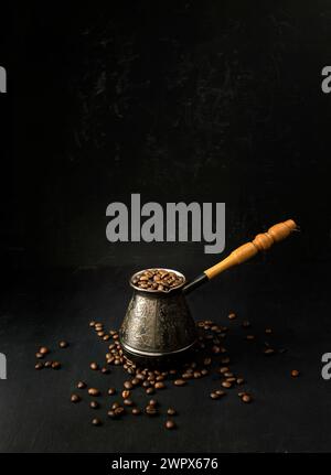 Geröstete Kaffeebohnen auf dunklem Hintergrund. Kopierbereich. Banner mit geröstetem Kaffee. Brauner gerösteter Kaffee. Kaffeekonzept. Kaffee auf dem Tisch, heiß Stockfoto