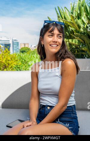 Porträt einer Frau, die auf einer Couch sitzt, mit ihrem und ihrem vertikalen Bild Stockfoto