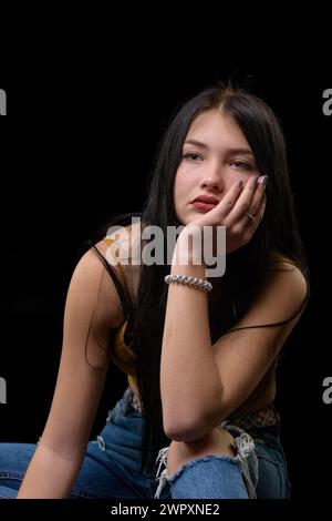 studio-Porträt eines jungen Mädchens in zerrissener Jeans Stockfoto