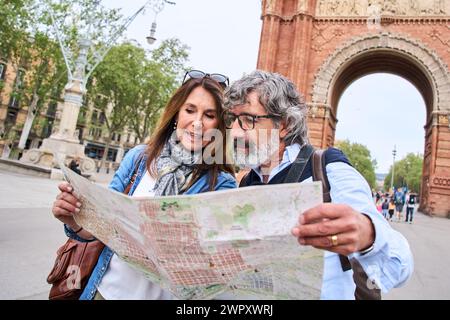 Kaukasisches Erwachsenenreisenpaar mit lokaler Karte, um die europäische Stadt zu besuchen. Sehenswürdigkeiten in Barcelona. Stockfoto