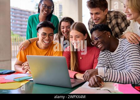 Eine große Gruppe junger multirassischer Schüler versammelte sich im Klassenzimmer, lächelte und beobachtete sie lustig Stockfoto