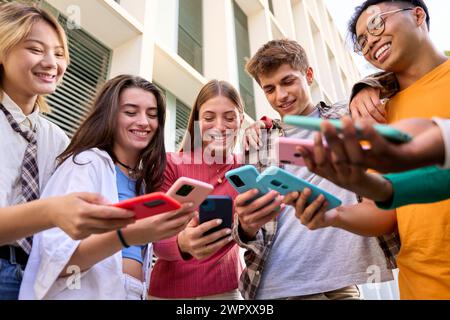 Gruppe von multirassischen Generation z Young Lächeln glücklich, sich lustige Videos auf einem Smartphone anzusehen Stockfoto