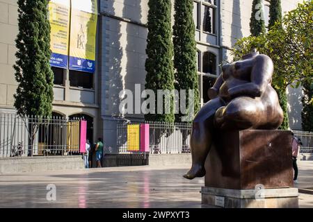 MEDELLIN, KOLUMBIEN - 17. JANUAR 2024: Sitzende Frau. Bronzeskulpturen des berühmten kolumbianischen Künstlers Fernando Botero Angulo auf dem Platz, der trägt Stockfoto