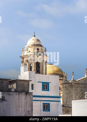 Turm der Kathedrale von Cadiz (Catedral de la Santa Cruz de Cádiz), von der engen Straße in der Altstadt, Andalusien, Spanien aus gesehen Stockfoto
