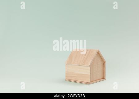 Vereinfachtes hölzernes Hausmodell isoliert auf hellgrünem Hintergrund Stockfoto
