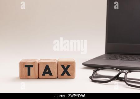 Steuerkonzept mit Brille und Laptop auf weißem Hintergrund. Stockfoto