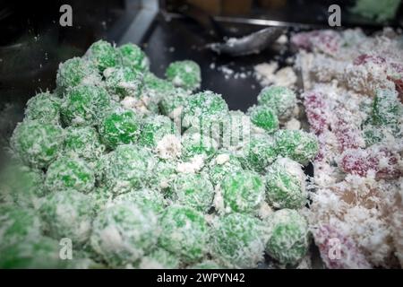 Kue Klepon, traditioneller indonesischer Kuchen aus klebrigem Reismehl, gefüllt mit braunem Zucker, bedeckt mit geriebener Kokosnuss Stockfoto