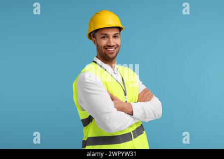 Ingenieur im Schutzhelm auf hellblauem Hintergrund Stockfoto