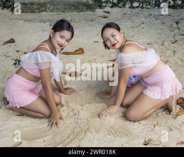 Zwei attraktive Frauen, die sich am Sandstrand entspannen Stockfoto