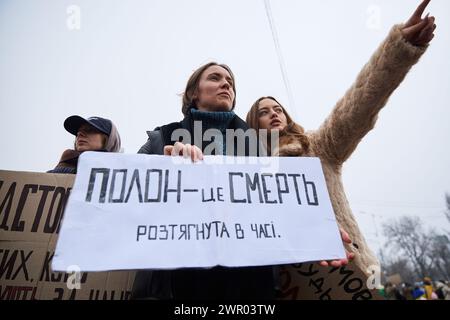 Ukrainische Frau hält ein Banner „Gefangenschaft ist Ein Tod gedehnt in der Zeit“ auf einer Demonstration für die Freilassung der gefangenen Verteidiger der Ukraine. Kiew - 11. Februar 2024 Stockfoto