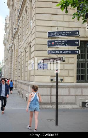 Eine Frau, die an den Hinweisschildern zum Place Louis-Lépine vorbeiwacht, einem Platz im 4. Arrondissement von Paris an der île de la Cité Stockfoto