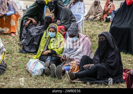 Frauen verfolgen Verfahren bei der Verteilung von Lebensmittelspenden an bedürftige Mitglieder der muslimischen Gemeinschaften durch die Regierung Kenias vor dem Ramadan in Nakuru. Die kenianische Regierung spendete vor dem Ramadan Nahrungsmittel an bedürftige muslimische Gemeindemitglieder. Stockfoto