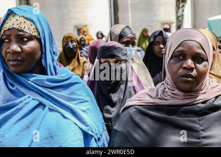 Frauen verfolgen Verfahren bei der Verteilung von Lebensmittelspenden an bedürftige Mitglieder der muslimischen Gemeinschaften durch die Regierung Kenias vor dem Ramadan in Nakuru. Die kenianische Regierung spendete vor dem Ramadan Nahrungsmittel an bedürftige muslimische Gemeindemitglieder. Stockfoto