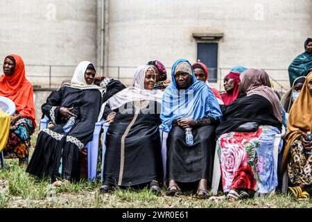 Frauen verfolgen Verfahren bei der Verteilung von Lebensmittelspenden an bedürftige Mitglieder der muslimischen Gemeinschaften durch die Regierung Kenias vor dem Ramadan in Nakuru. Die kenianische Regierung spendete vor dem Ramadan Nahrungsmittel an bedürftige muslimische Gemeindemitglieder. Stockfoto