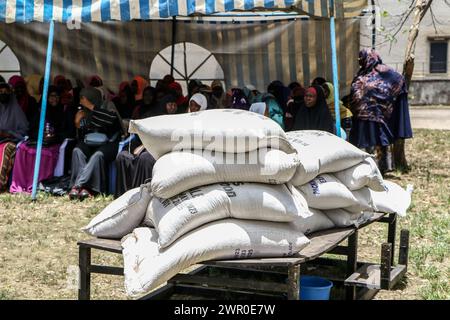 Frauen verfolgen Verfahren bei der Verteilung von Lebensmittelspenden an bedürftige Mitglieder der muslimischen Gemeinschaften durch die Regierung Kenias vor dem Ramadan in Nakuru. Die kenianische Regierung spendete vor dem Ramadan Nahrungsmittel an bedürftige muslimische Gemeindemitglieder. Stockfoto