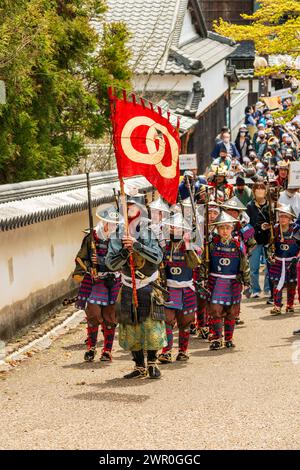 Japanische Kinder, gekleidet als Teppou-Aschigaru-Soldaten mit Streichholzwaffen, marschieren bei der Samurai-Parade auf einer Straße in der Burgstadt Tatsuno entlang. Stockfoto