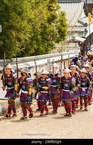 Japanische Kinder, gekleidet als Teppou-Aschigaru-Soldaten mit Streichholzwaffen, marschieren bei der Samurai-Parade auf einer Straße in der Burgstadt Tatsuno entlang. Stockfoto