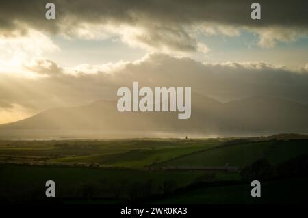 Blick auf die Dundrum Bay, Newcastle & Mourne Mountains; Winternachmittag; Sonnenstrahlen brechen durch die Wolkendecke. Stockfoto