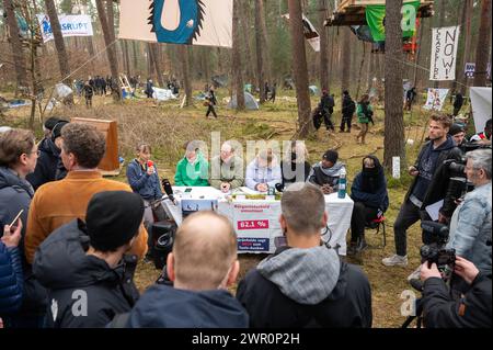 Brandenburg, Deutschland. März 2024. 10. März 2024, Brandenburg, Grünheide: Aktivisten sprechen bei einer Pressekonferenz in einem Protestlager in einem Waldgebiet nahe der Tesla-Fabrik. Das Protestlager richtet sich gegen eine geplante Erweiterung des Werksgeländes Tesla in einem bewaldeten Gebiet in der Nähe der Fabrik. Foto: Christophe Gateau/dpa Credit: dpa Picture Alliance/Alamy Live News Stockfoto