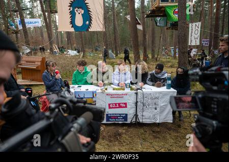 Brandenburg, Deutschland. März 2024. 10. März 2024, Brandenburg, Grünheide: Aktivisten sprechen bei einer Pressekonferenz in einem Protestlager in einem Waldgebiet nahe der Tesla-Fabrik. Das Protestlager richtet sich gegen eine geplante Erweiterung des Werksgeländes Tesla in einem bewaldeten Gebiet in der Nähe der Fabrik. Foto: Christophe Gateau/dpa Credit: dpa Picture Alliance/Alamy Live News Stockfoto