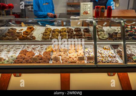 Nahaufnahme des Innenraums eines Cafés mit verschiedenen Donuts in Regalen. Stockfoto