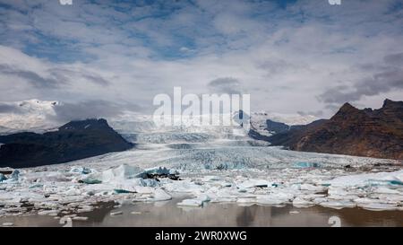Jokulsarlon Gletscherlagune im Sommer, mit geschmolzenen Eisbergen, spektakulärer Gletscherzunge und Himmel im Hintergrund, aus der Vogelperspektive Stockfoto