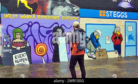 Glasgow, Schottland, Großbritannien. 10. März 2024: Fans kamen zu den Kunstwerken am Ufer des Flusses clyde. Willy Wonka Debacle Wandgemälde erschien auf der clyde Side Graffiti Wand auf dem clyde Walkway. Das Gemälde wurde von dem Künstler Ejek geschaffen, nachdem das Film Experience Event zu nationalen Nachrichten wurde. Das Kunstwerk zeigt die Schauspielerinnen, die bei der Veranstaltung als Oompa Loompa und „The Unknown“ aus dem Skript für künstliche Intelligenz arbeiteten. Credit Gerard Ferry/Alamy Live News Stockfoto