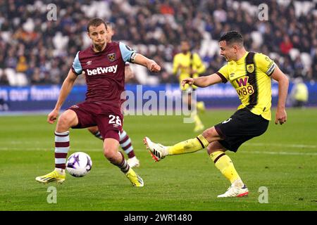 Burnleys Josh Cullen (rechts) kreuzt den Ball, den Konstantinos Mavropanos von West Ham United (nicht abgebildet) über ein eigenes Tor für Burnleys zweites Tor im Spiel der Premier League im London Stadium erzielt. Bilddatum: Sonntag, 10. März 2024. Stockfoto