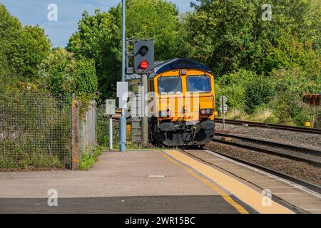 Dieselbetriebene Eisenbahnlinie Personenbeförderungsstrecke england großbritannien Güterzug durch den Vorortbahnhof des Landes. Stockfoto