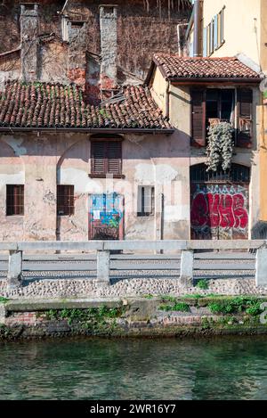 Haus in einem Innenhof an der Alzaia Naviglio Grande im alten Mailand, Ruine, baufällig. Mit einem kaputten Dach und Blick auf den Naviglio. Italien. Stockfoto