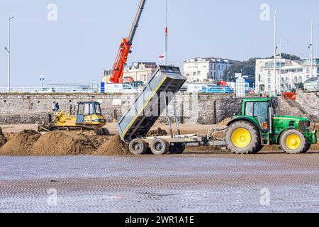 Bulldozer und Traktor bewegen Sand am Weston Super Mare Beach, um die Auswirkungen der langen Küstendrift vor der Sommersaison zu bekämpfen Stockfoto