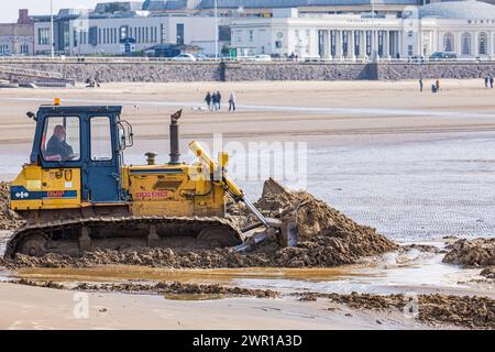 Der Bulldozer bewegt Sand am Weston Super Mare Beach, um den Auswirkungen der langen Küstendrift vor der Sommersaison entgegenzuwirken Stockfoto