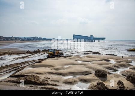 Der Bulldozer bewegt Sand am Weston Super Mare Beach, um den Auswirkungen der langen Küstendrift vor der Sommersaison entgegenzuwirken Stockfoto