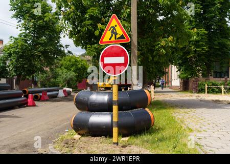 Ein Straßenschild steht an der Seite einer Landstraße und gibt Fahrern und Fußgängern Wegbeschreibungen. Stockfoto